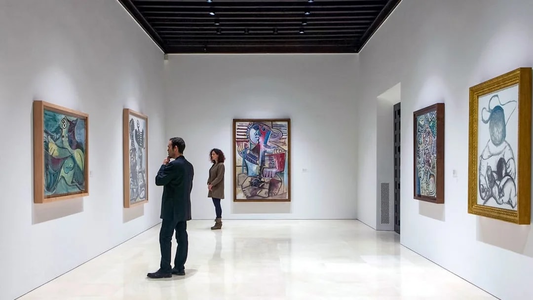 Visitors viewing paintings at Picasso Museum in Malaga.