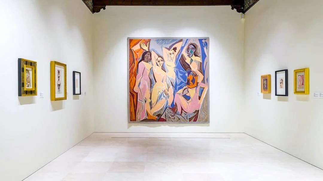 Artworks displayed at the Picasso Museum in Malaga, featuring a large central painting.