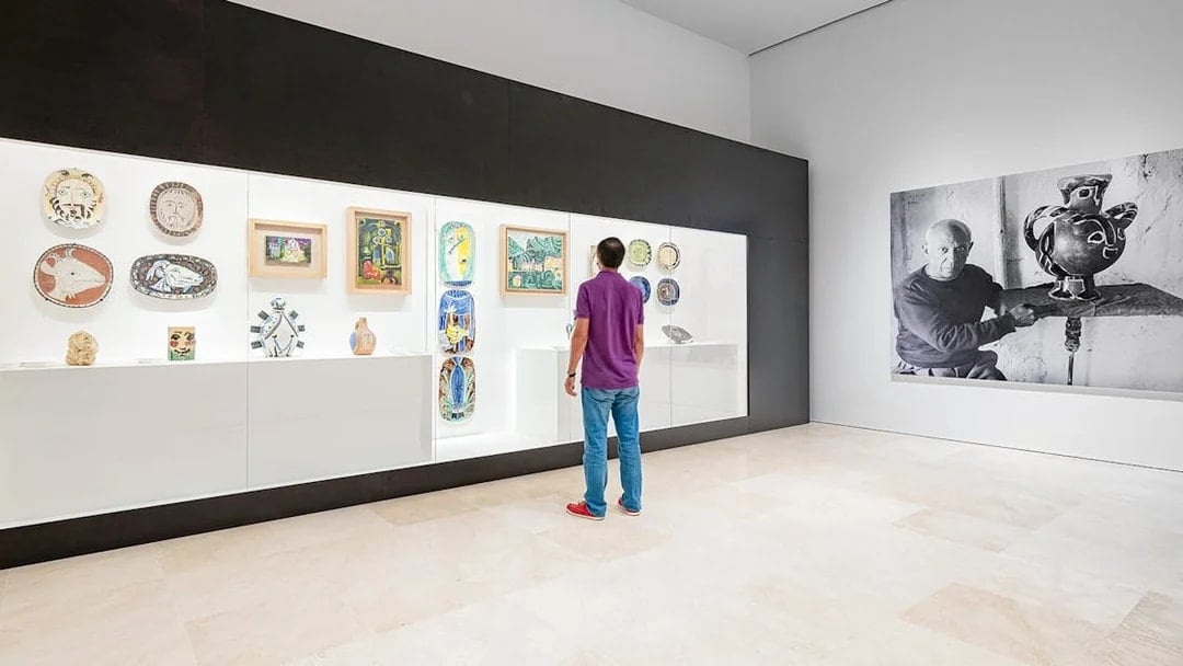 Visitor viewing Picasso ceramics and paintings at Picasso Museum Malaga.