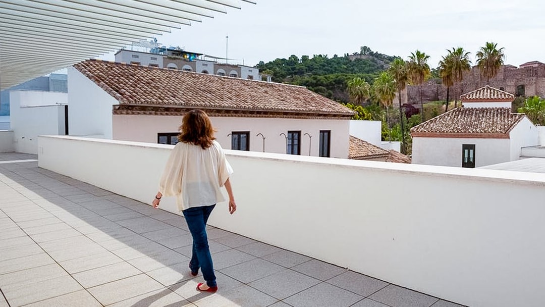Visitor walking on the terrace of the Picasso Museum in Malaga, with cityscape views.