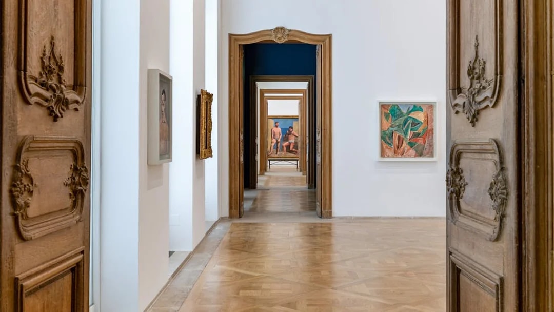 Picasso Museum hallway with framed artworks and ornate wooden doors.