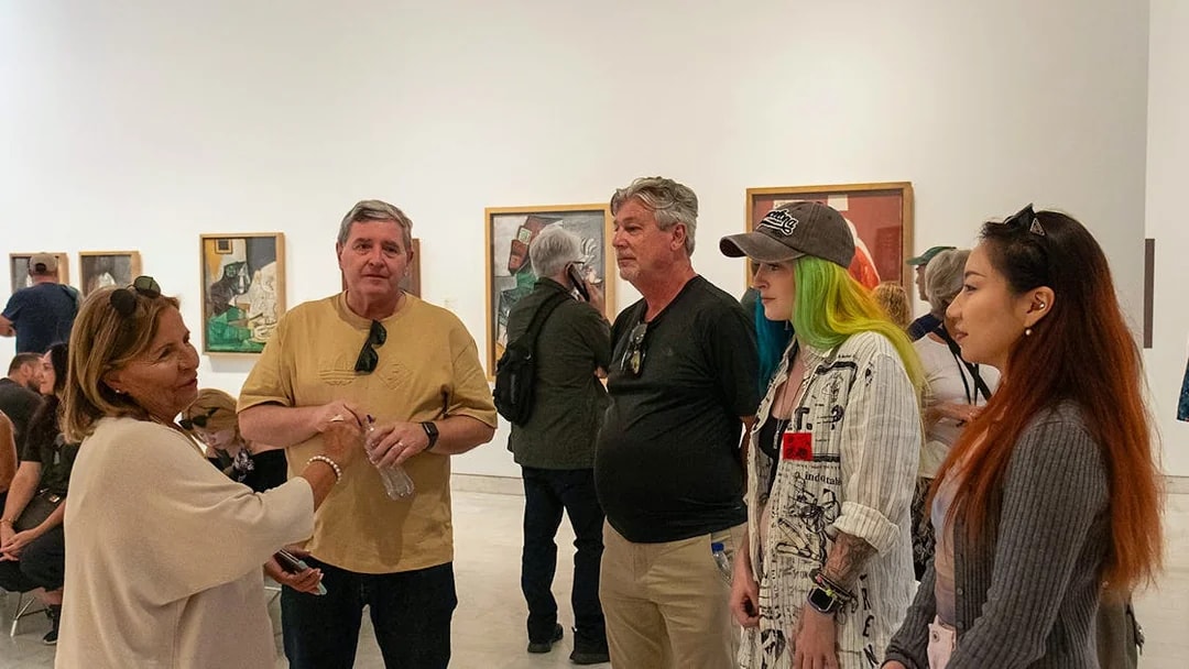 Visitors on a guided tour at the Picasso Museum, viewing artwork.