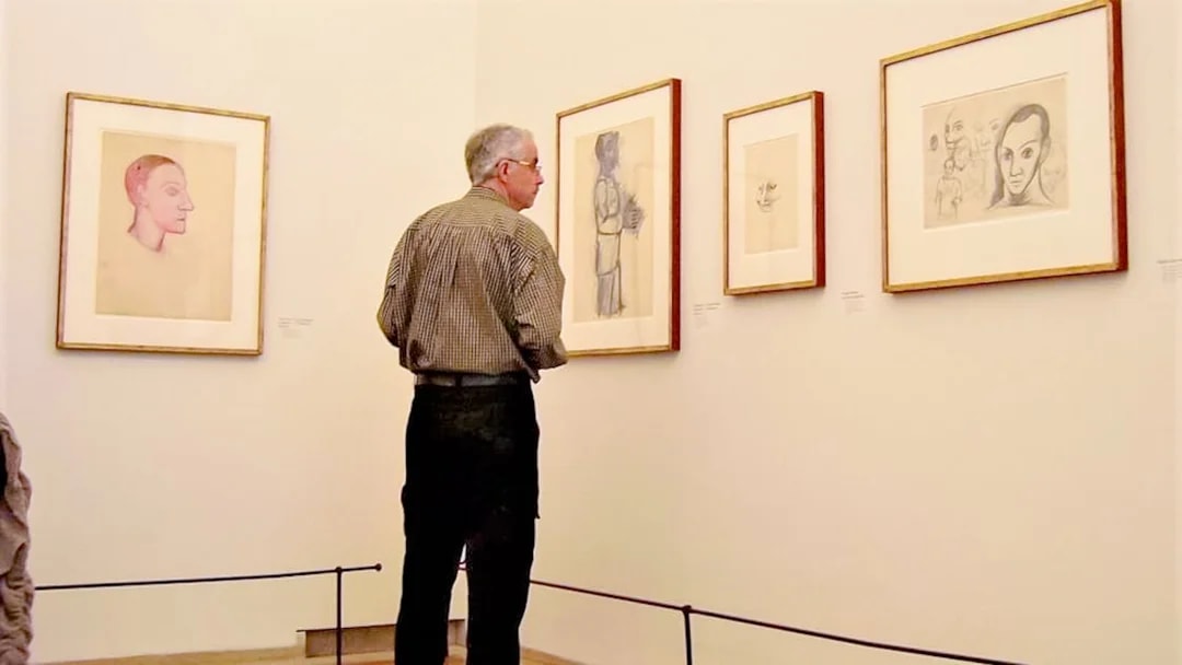 Man observing Picasso sketches at Picasso Museum.