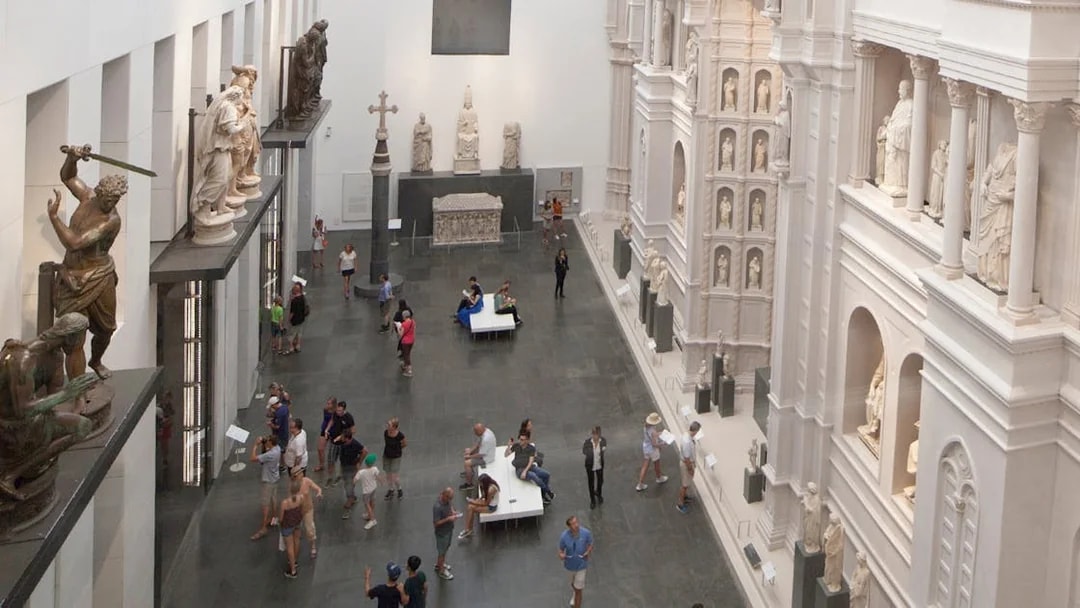 Sculpture Gallery at Opera del Duomo Museum in Florence with visitors exploring exhibits.