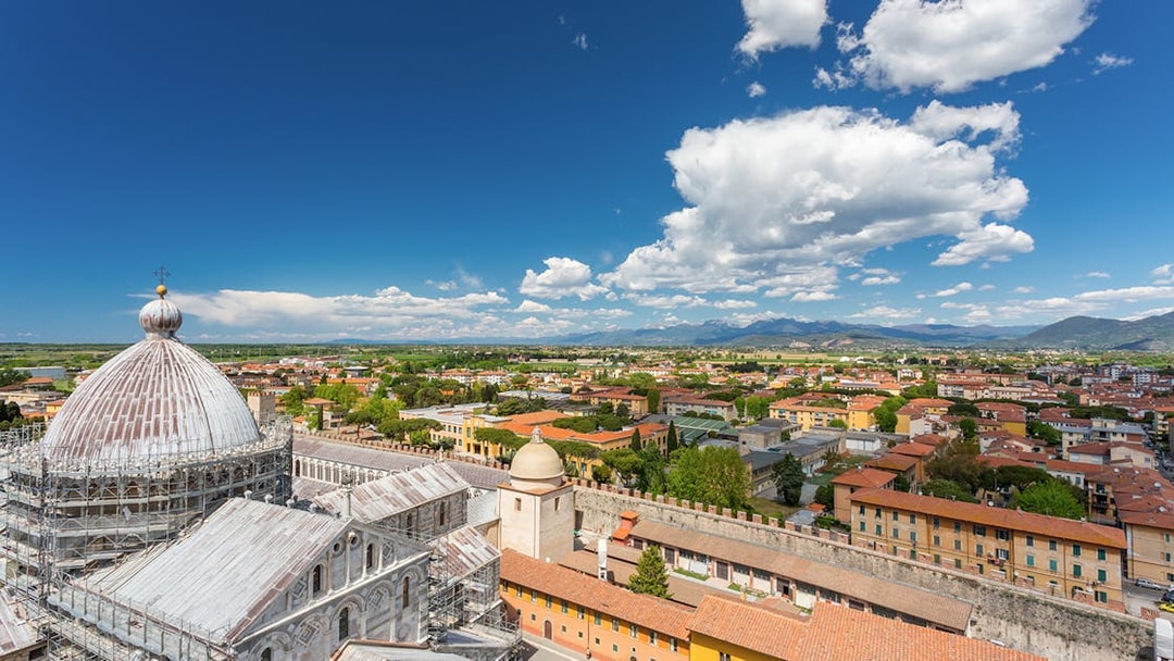 Panoramic view of Pisa cityscape from the top of the Leaning Tower, featuring the cathedral dome.