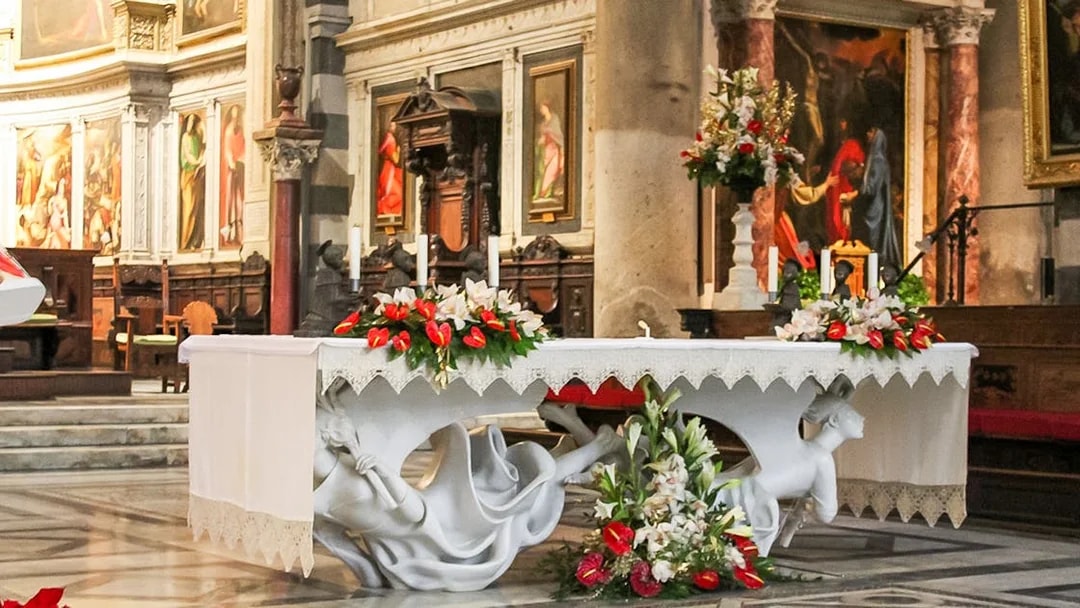 Altar inside Pisa Cathedral with ornate sculptures and floral decorations.