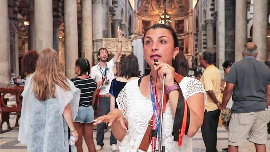 Tour guide explaining Pisa Cathedral interior to visitors.