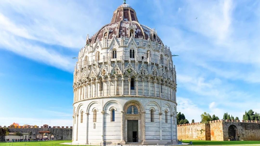 Pisa Baptistery with guided tour group in foreground, Leaning Tower visible in background.