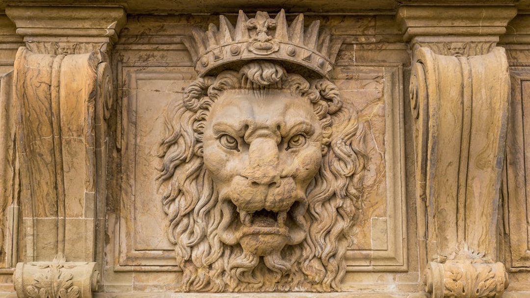 Stone lion sculpture with crown at Pitti Palace, Florence.