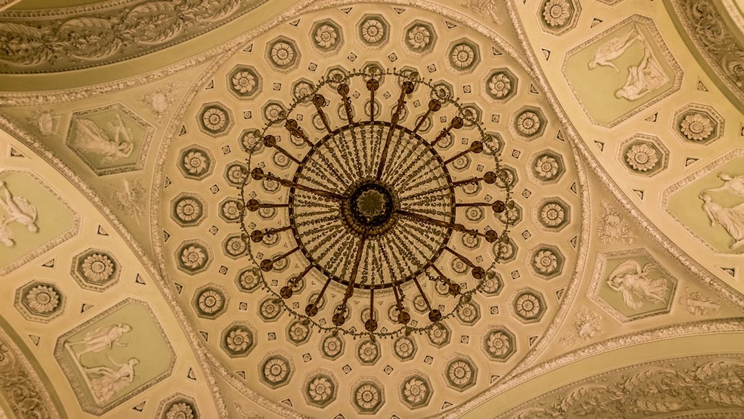Ornate ceiling and chandelier inside Pitti Palace, Florence, Italy.