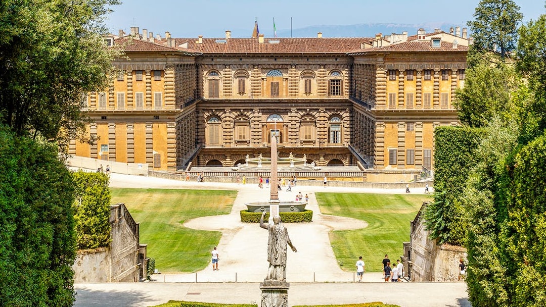 Gardens and exterior view of Pitti Palace in Florence, Italy, with visitors exploring.