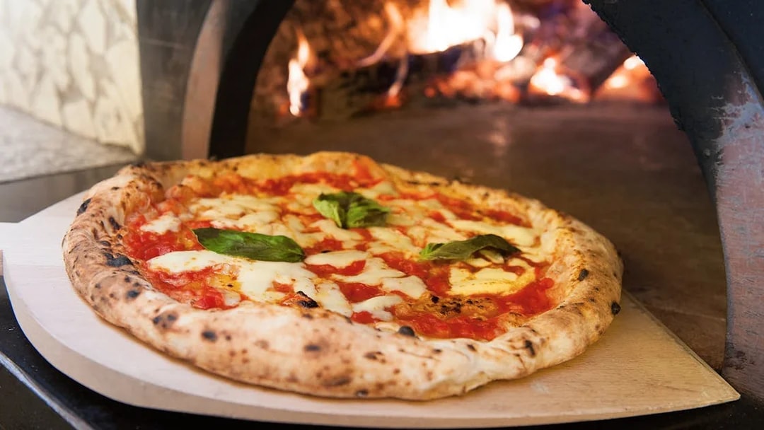Wood-fired pizza with basil in a Florence cooking class.
