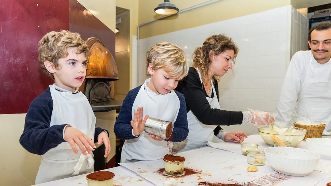 Kids making tiramisu in a Rome cooking class kitchen.