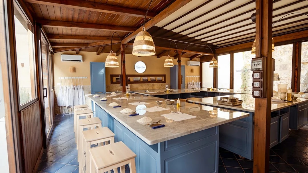 Cooking class setup with ingredients on marble counters in Palermo.