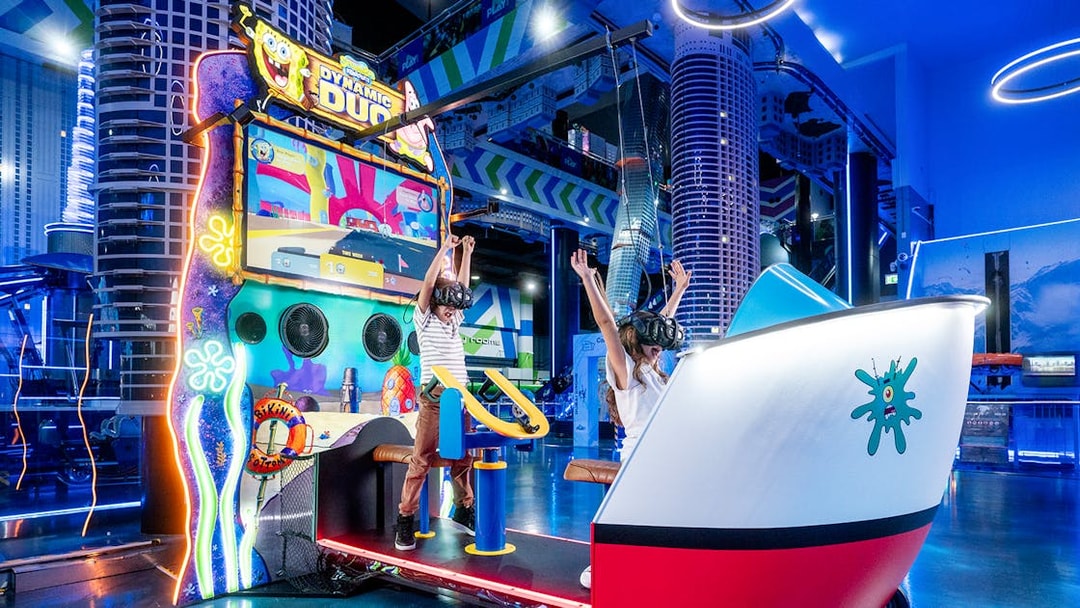 Children enjoying virtual reality game at Play DXB, Dubai with VR headsets and interactive controls.