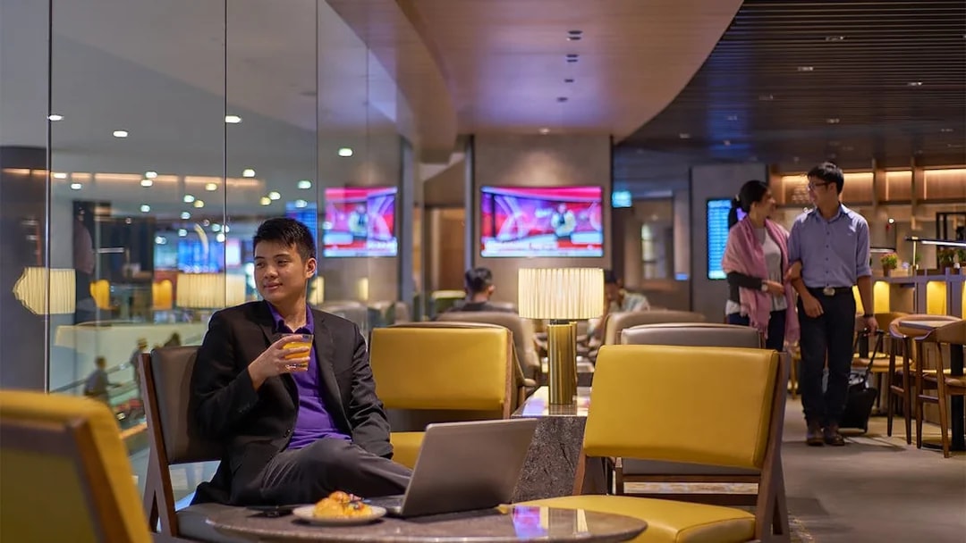 Man enjoying a drink at Plaza Premium Lounge, Kuala Lumpur International Airport.