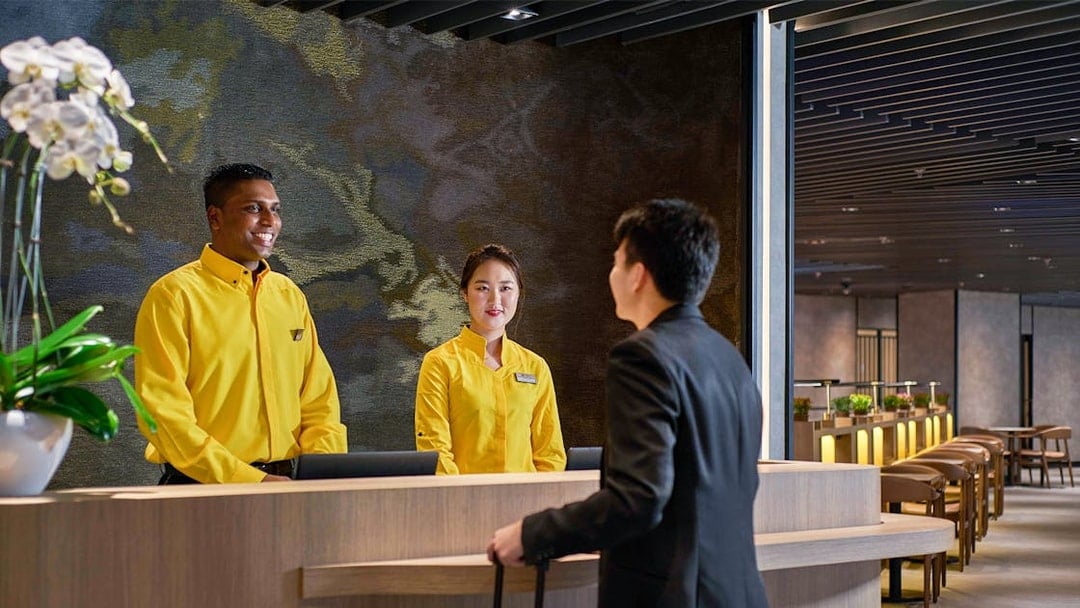 Reception staff assisting a traveler at Plaza Premium Lounge, KLIA Terminal 2.