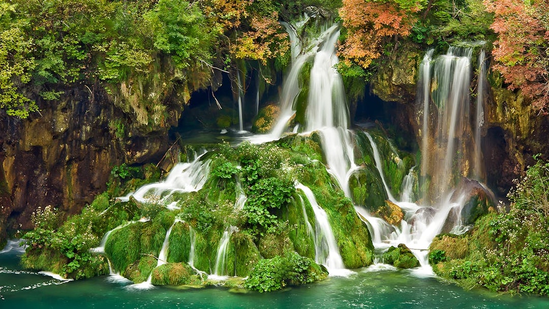 Waterfalls cascading over mossy rocks at Plitvice Lakes National Park, Croatia.