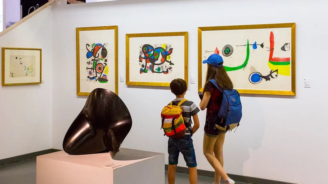 Tourists viewing abstract art in Poble Espanyol museum, Barcelona.