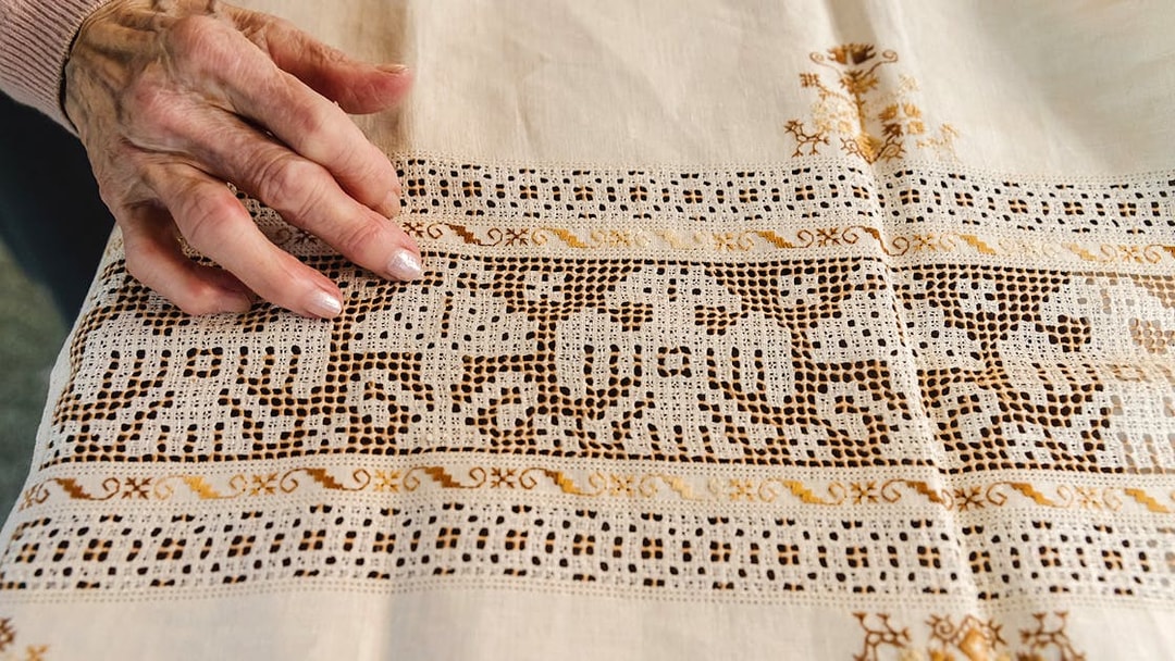 Hand touching intricate lacework at Poble Espanyol, Barcelona.