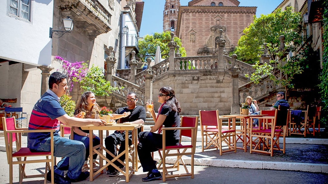 Visitors enjoying a meal at an outdoor cafe in Poble Espanyol, Barcelona.
