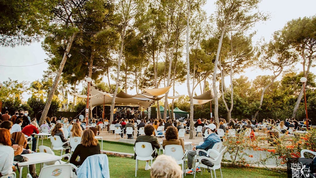 Tourists enjoying food at an outdoor concert in Poble Espanyol, Barcelona.
