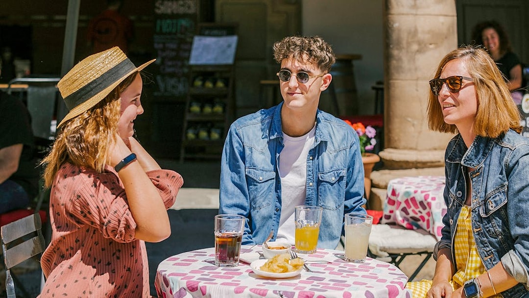 Visitors enjoying drinks at an outdoor café in Poble Espanyol, Barcelona.