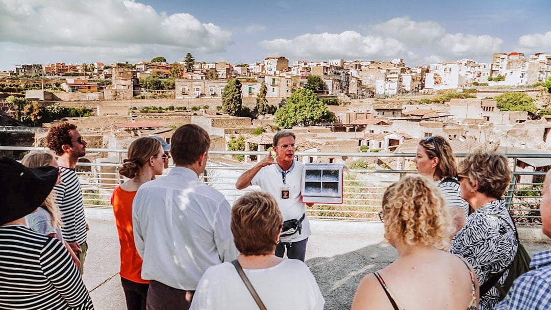 Guide explaining ruins to tour group at Herculaneum, Italy.