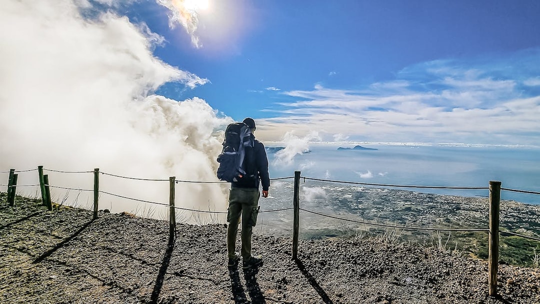 Hiker overlooking the view from Mount Vesuvius summit, Italy.