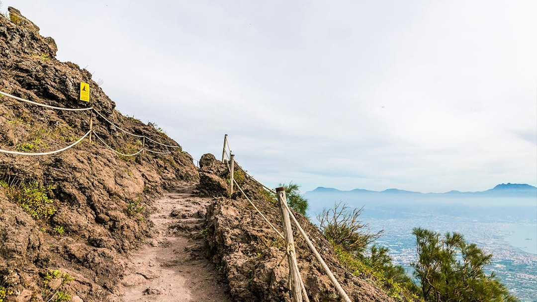 Rocky path on Mount Vesuvius with view of Naples in the distance.