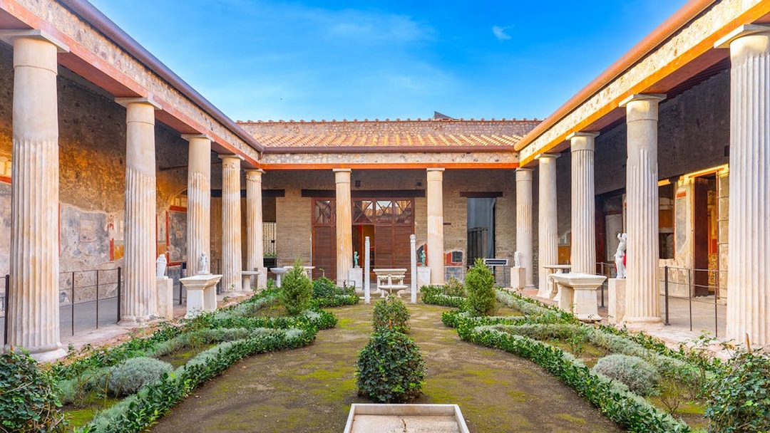 Pompeii garden with ancient columns and greenery in Italy.