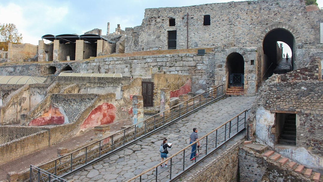 Visitors ascending a stone path at Pompeii ruins, Italy.