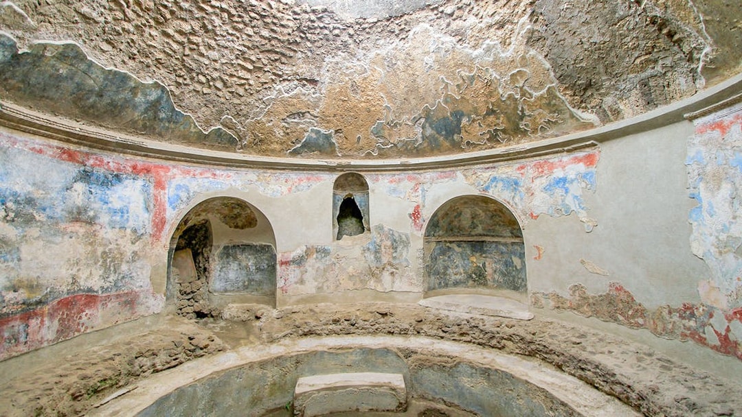 Stabian Baths in Pompeii with ancient frescoes and stone seating.