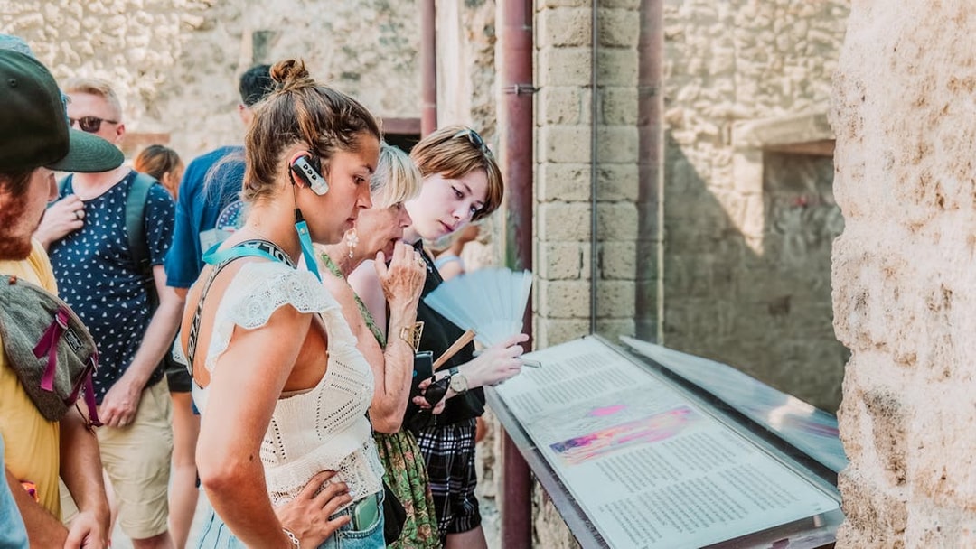 Tourists using audioguides at Pompeii archaeological site, Italy.