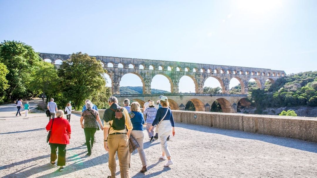 Visitors walking towards Pont du Gard aqueduct in France.