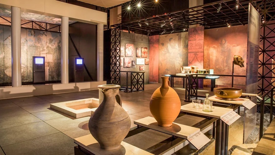 Museum exhibit with ancient pottery and artifacts at Pont du Gard, France.