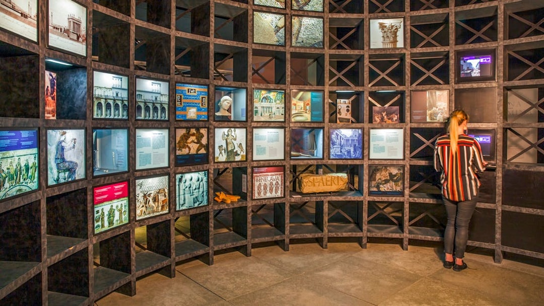 Exhibit at Pont du Gard museum with historical displays and visitor interacting with a screen.