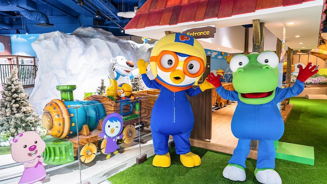 Pororo and friends at Pororo Park Singapore with colorful train and snowy backdrop.