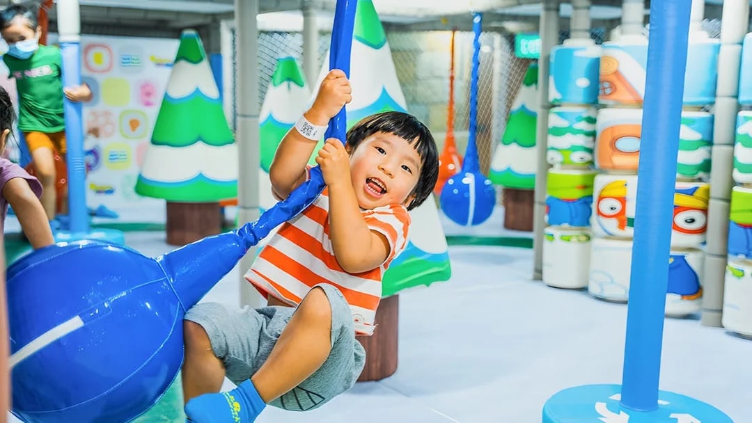 Child playing on a swing at Pororo Park Singapore indoor playground.
