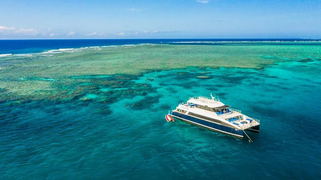 Cruise ship anchored at Great Barrier Reef with clear blue waters.