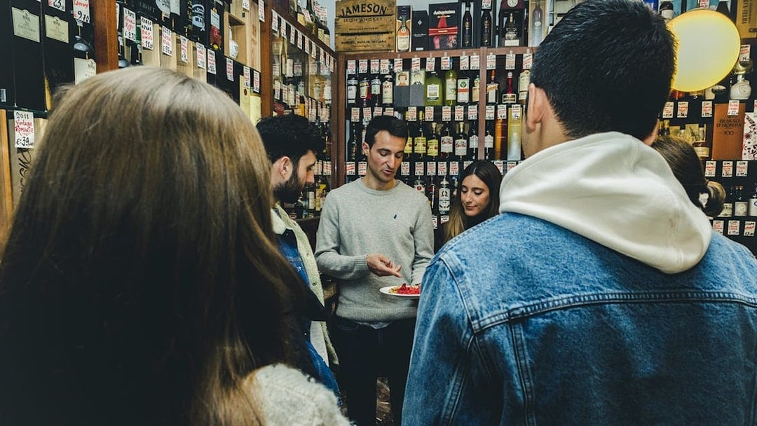 Group tasting wine and food in a Porto shop during a tour.