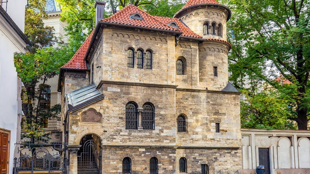 Historic building in Prague's Jewish Quarter with red-tiled roof and arched windows.