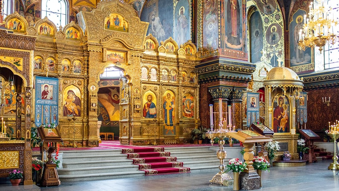 Interior of St Vitus Cathedral featuring ornate gold altar and religious iconography.