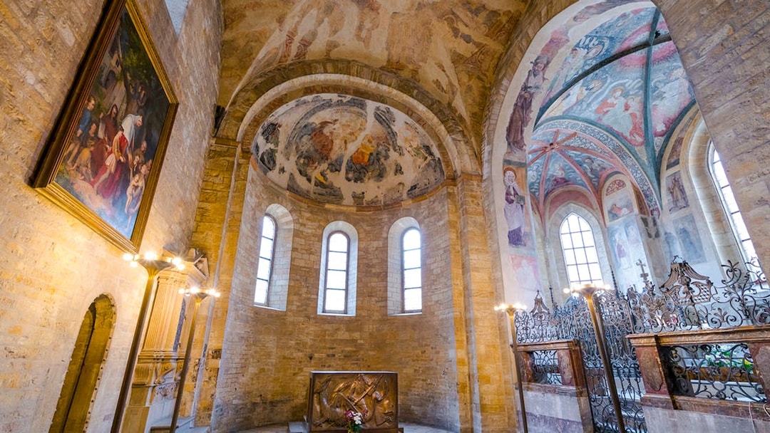 Basilica of St George interior with frescoed ceilings and arched windows.
