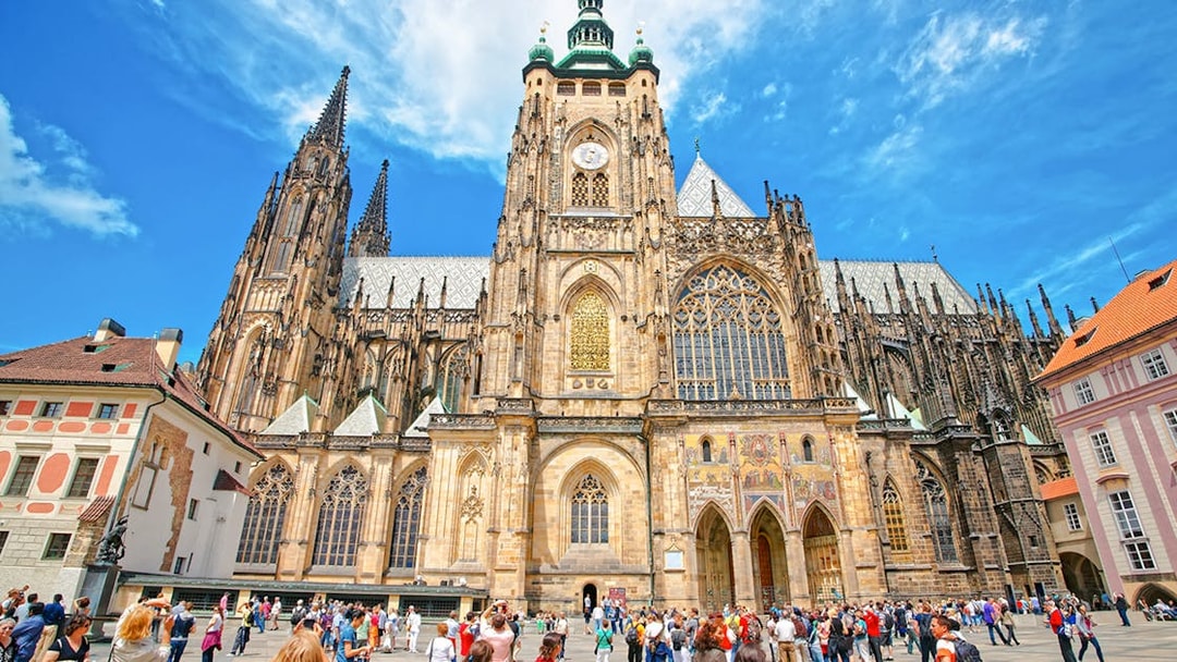 St Vitus Cathedral exterior at Prague Castle with tourists in the foreground.