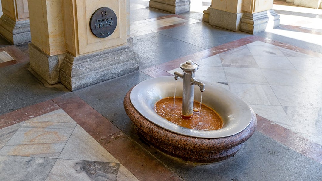 Karlovy Vary thermal spring fountain with mineral water flowing, Czech Republic.