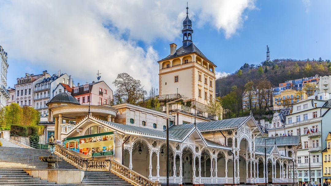 Karlovy Vary colonnade and historic buildings with Watchtower Diana in the background.