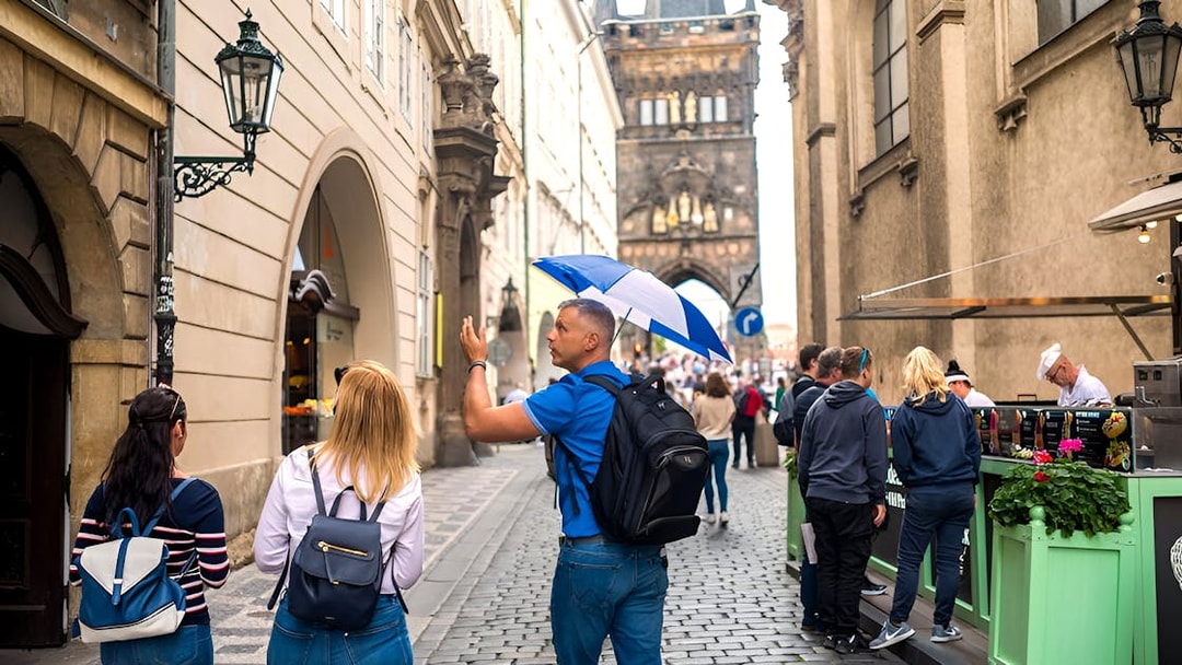 Tour guide leading a group through Prague Old Town near Charles Bridge.