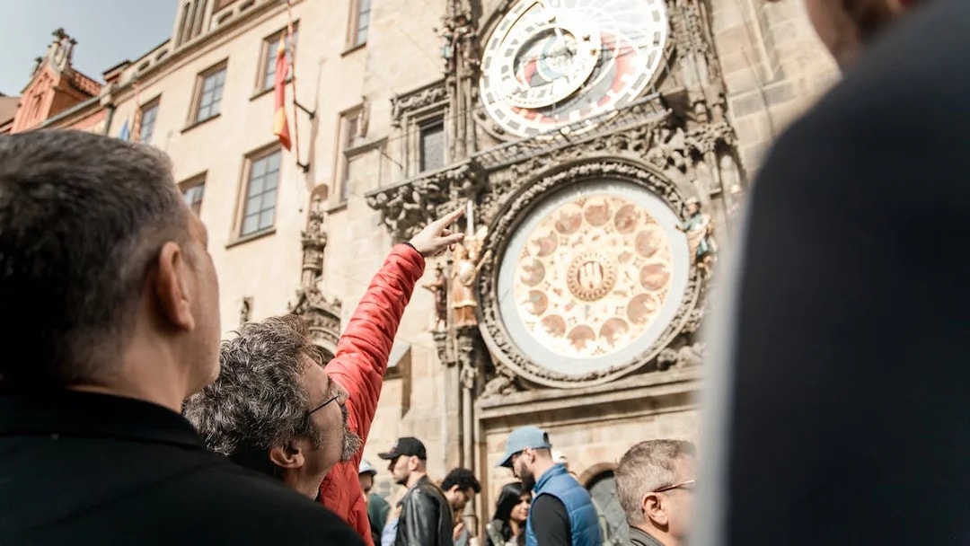 Tourists observing the Prague Astronomical Clock during Old Town tour.