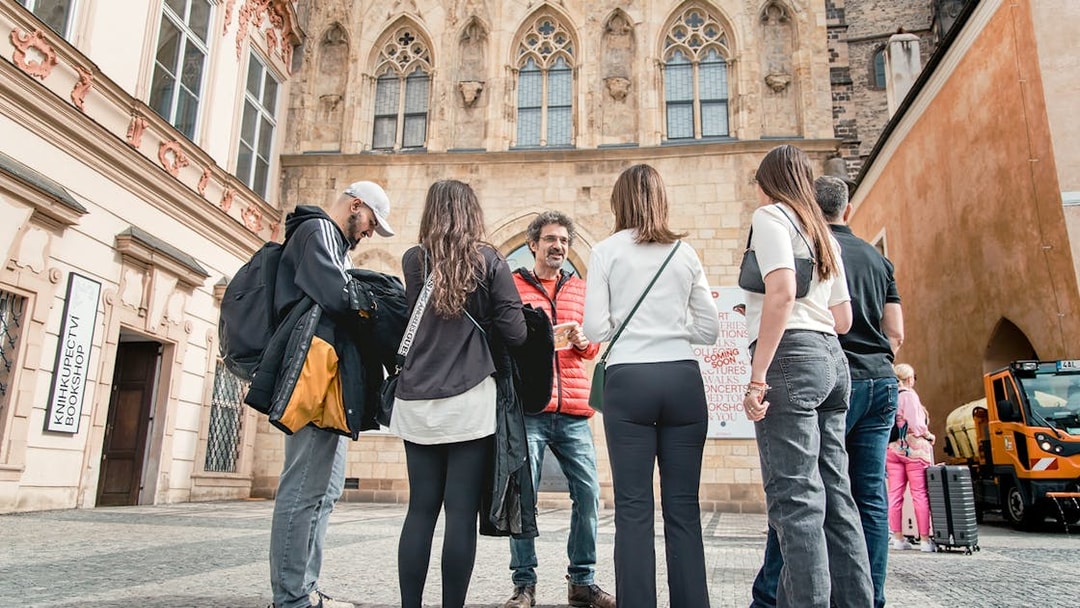 Tour group with guide in Prague Old Town near historic building.